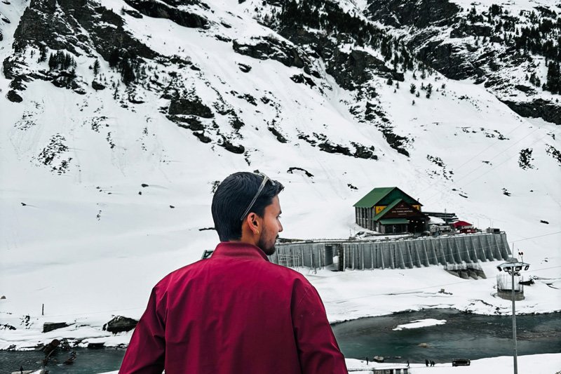 Taxi parked on a snowy mountain road near Rohtang